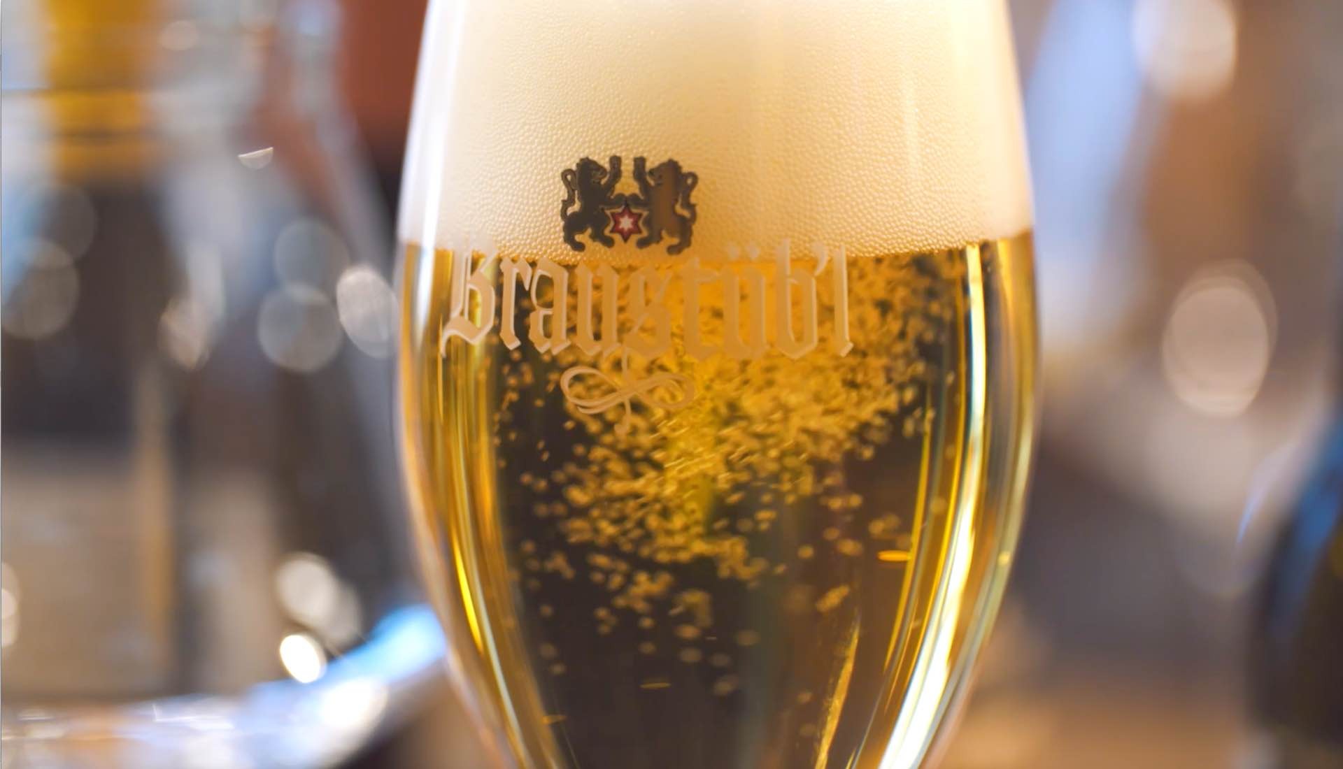 Nahaufnahme eines vollen Bierglases mit Schaumkrone und dem Schriftzug 